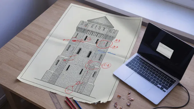 Printed masonry elevation with zone scores next to a laptop showing a small language-model prompt, cool daylight, no logos